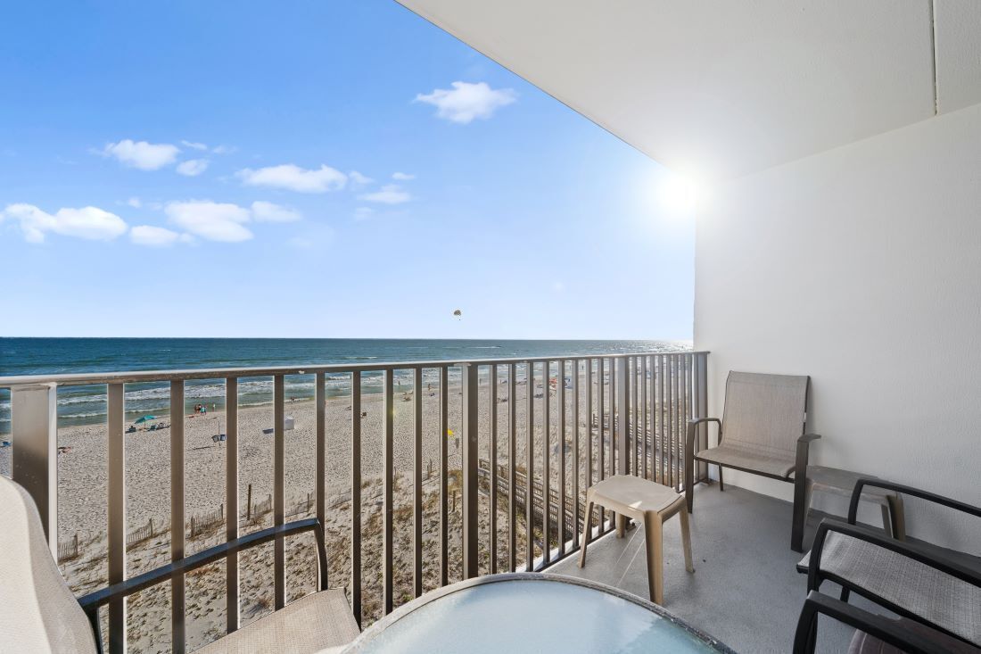 A balcony with a view of the beach and ocean.