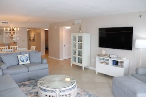 A living room with a sofa, a round table, a cabinet, and a TV.