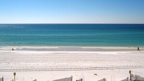 Une plage avec un ciel dégagé, une mer calme et un rivage sablonneux.