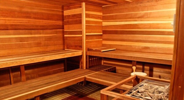 A sauna with wooden benches and a bench with a towel rack. - Hotel Style Room in the Heart of Whitefish Mountain Resort Village (Whitefish)