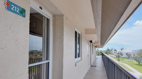 A balcony with a clear view of the surrounding area, including a street and greenery. - WHATA VIEW! Sanibel Siesta Unit #212 (Sanibel)