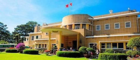 A large, multi-story building with a prominent entrance and a flag on top.
