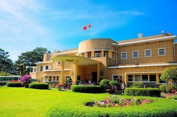 A large, multi-story building with a prominent entrance and a flag on top.