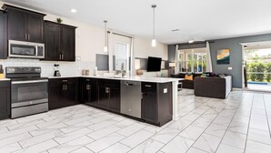 A modern kitchen with dark cabinetry, a built-in microwave, and a dishwasher.