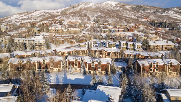 A snow-covered mountain town with multiple chalet-style buildings, likely a ski resort.