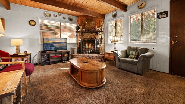Un salon chaleureux avec une cheminée, des meubles en bois et un téléviseur.