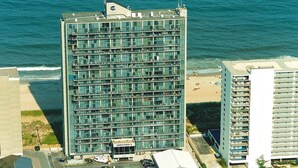 Un hôtel de grande hauteur, avec de nombreux étages, un parking et une vue sur la plage.
