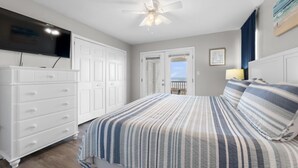 A bedroom with a bed, a ceiling fan, a dresser, and a television. - Beach Front Duplex with Gulf Views | Sleeps 11 (Gulf Shores)