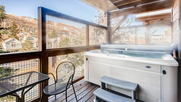 A hot tub on a wooden deck with a view of houses and trees. - Walk to Lifts and Main Street - Private Hot Tub I Managed by Park City Lodging (Park City)