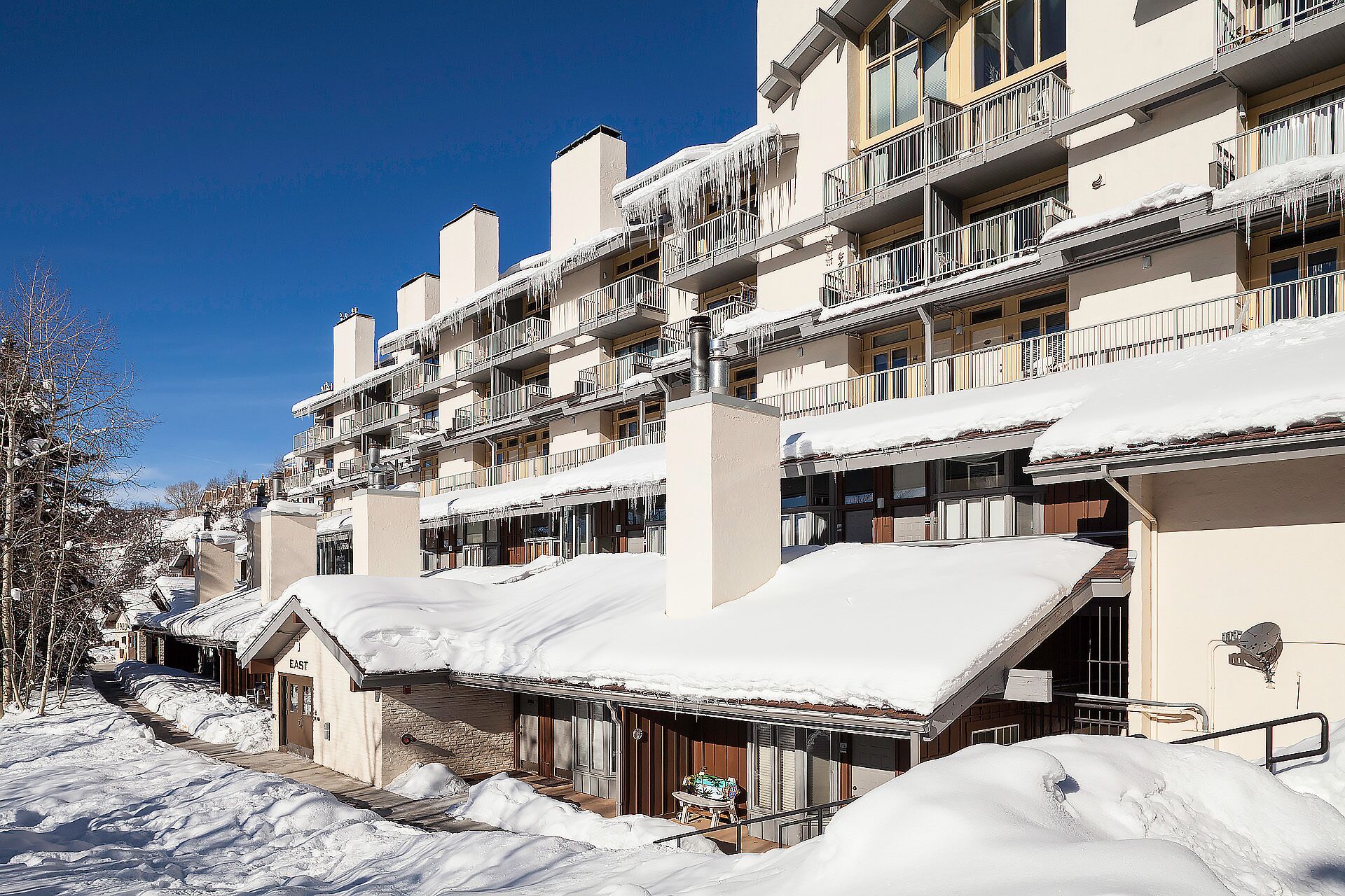 Ein mehrstöckiges Hotel mit Balkonen und schneebedeckten Dächern.
