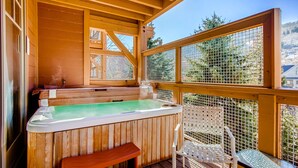 A wooden deck with a hot tub, a bench, and a table. - Managed by Park City Lodging-Great location, just a short walk to Main Street. (Park City)