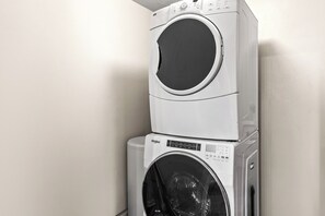 A stacked washer and dryer unit in a corner with a plain wall background. - Great location to Old Town/Main Street| Hot Tub | Managed by Park City Lodging (Park City)