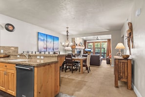 A kitchen with granite countertops, a dishwasher, and a dining area with a table and chairs. - Great location to Old Town/Main Street| Hot Tub | Managed by Park City Lodging (Park City)