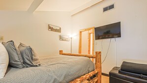 A bedroom with a bed, a wooden headboard, a television mounted on the wall, and a suitcase on the floor. - Center Village Ski In/Out Perfectly decorated and sleeps 6 Walk to everything (Copper)