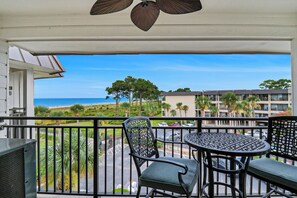 Enjoy the ocean view from this balcony with a table and chair, perfect for taking in the sights.