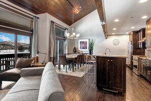 The open concept living room, dining and kitchen area with high ceilings.