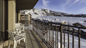 A balcony with a view of a snow-covered ski slope and buildings. - BT305 | Great Views | Walk to Base Area | Winter Shuttle | Ski In | Hot Tub (Steamboat Springs)