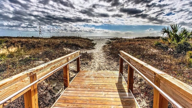 A wooden boardwalk leading to a beach with a cloudy sky. - Oceanfront Villa, Heated Beachside Pool! (Hilton Head)