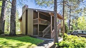 A two-story building with a wooden staircase leading to a balcony. - The Ridge at Sunriver - Condo #42 - Access provided to onsite seasonal swimming pool & tennis facilities, year-round hot tub plus 4 bikes (Sunriver)