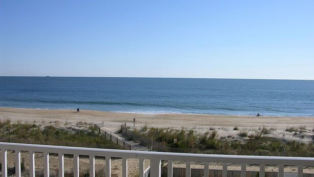 A beach with a wooden fence in the foreground and a clear view of the ocean. - Beachmark 3F-Oceanfront 73rd St, WIFI, Pool, Elev, W/D, AC (Ocean City)
