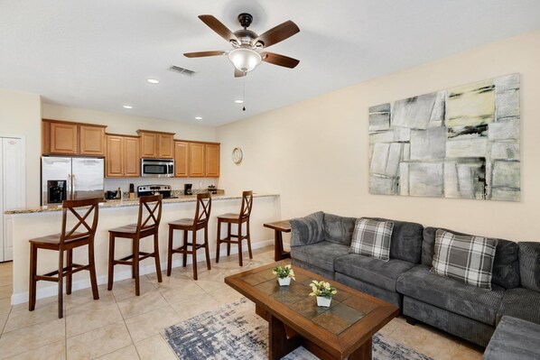 A modern kitchen with wooden cabinets, a built-in microwave, and a ceiling fan. - Paradise Palms Resort 4 Bedroom Townhome Pet Friendly (Kissimmee)