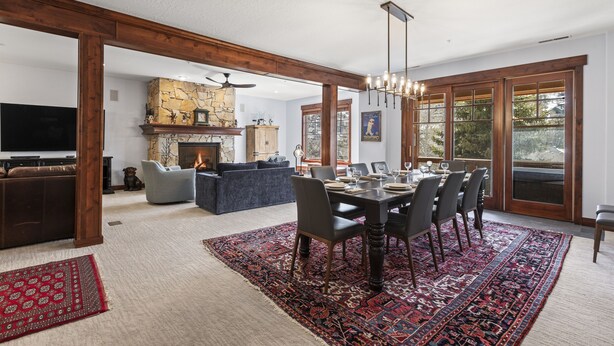 Un vaste espace de vie agrémenté d’une cheminée, d’une table à manger pouvant accueillir six personnes et d’une grande fenêtre offrant une vue sur l’extérieur.