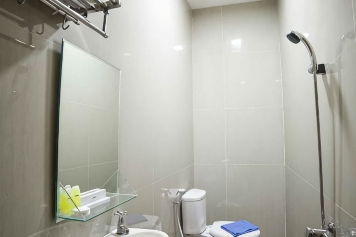 A modern bathroom with a glass shelf, a toilet, and a shower.