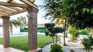 A covered patio area with a brick column, a small tree, and a well-maintained lawn. - Cottage with pool, garden with views and wifi (Dúrcal)