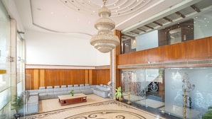 A spacious lobby with a large chandelier, a seating area with sofas, and a patterned floor. - Hotel SS Palace (Rameshwaram)