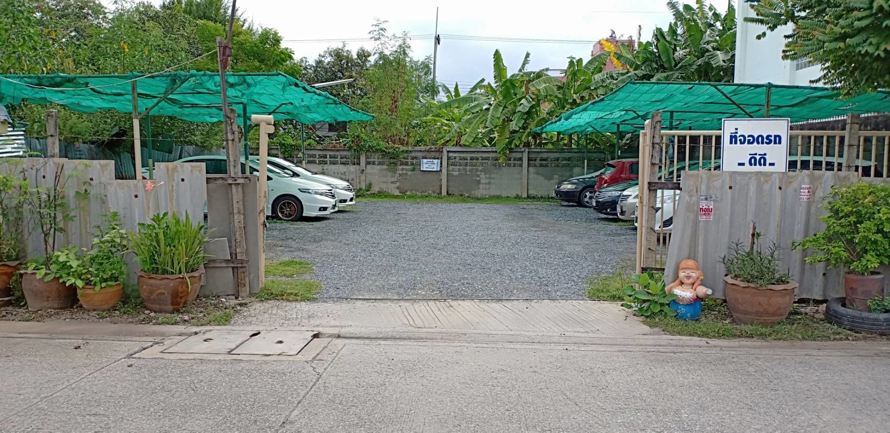 A gated parking area with a white car parked inside.
