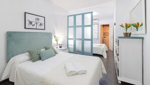 A hotel room with a bed, a nightstand, a dresser, and a bathroom visible through a frosted glass door. - Fidalsa Relax Pool your Refuge (Torrevieja)