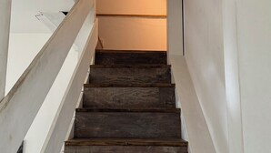 A staircase with wooden steps and white walls, leading to a higher floor. - Cottage in an old farmhouse (Frémainville)