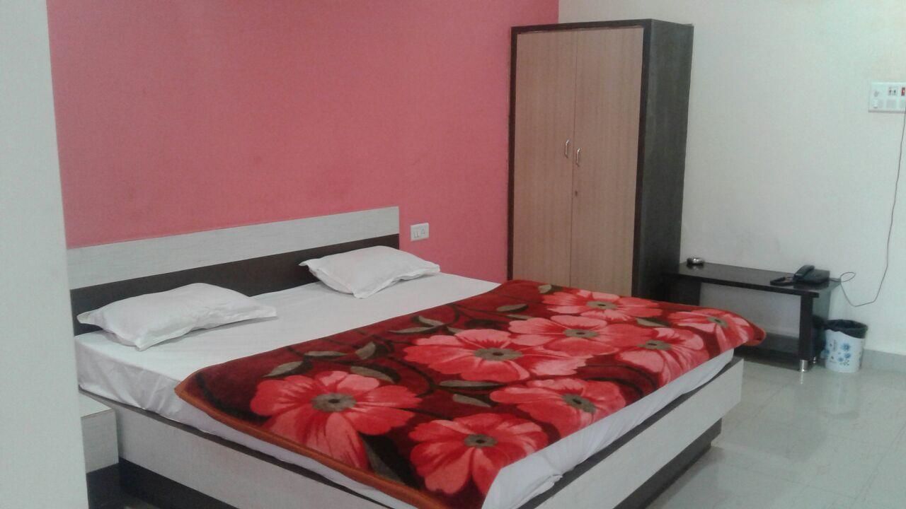 A bedroom with a bed, a wardrobe, and a bedside table.