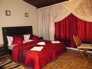 A hotel room with a large bed, red and white bedding, a wooden headboard, a chair, and a curtain. - Santa Roza Butik Otel (Beykoz)