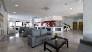 A spacious lobby with a grey sofa, a coffee table, and a modern kitchen area in the background. - Charming apartment with swimming pool 5 min from the sea  (San Bartolomé de Tirajana)