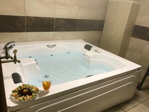 A white hot tub with a glass bowl of fruit and a glass of orange juice on the side. - Bolu Yildiz Hotel (Bolu)