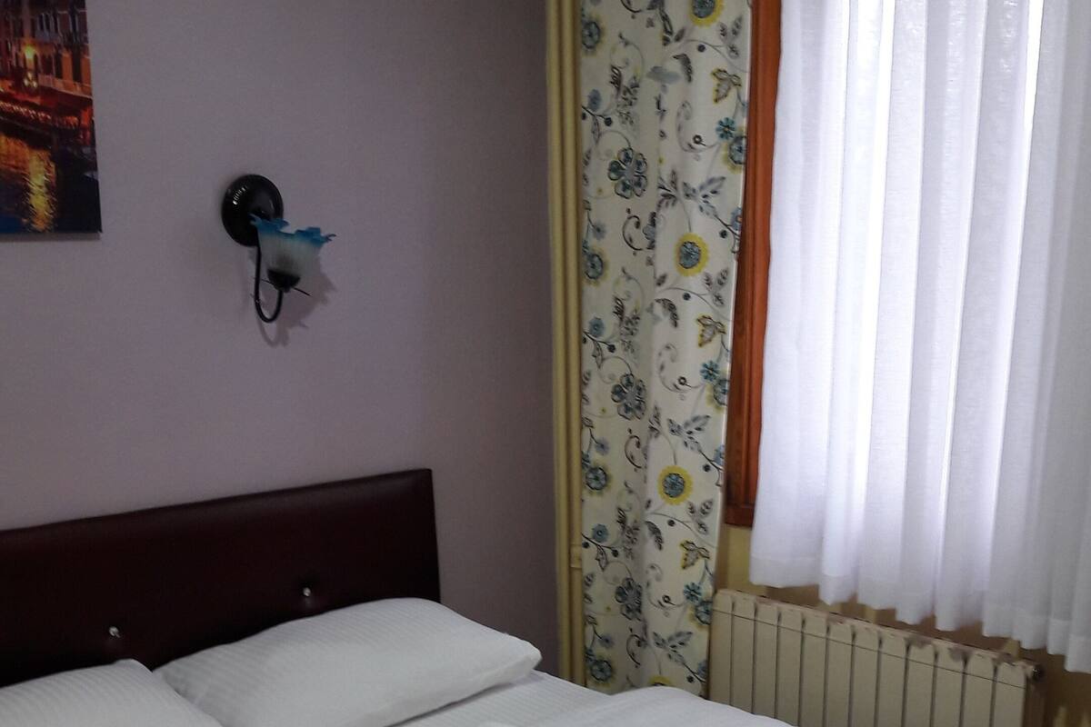 A neatly made bed with white linens and a floral-patterned duvet cover.