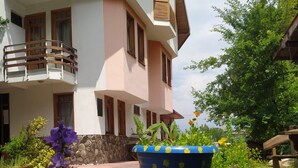 A two-story building with a balcony, a stone wall, and potted plants in the foreground. - Bolu Yildiz Hotel (Bolu)