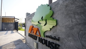 Indicador de Patoey House amb un logotip d'arbre i un símbol de casa.