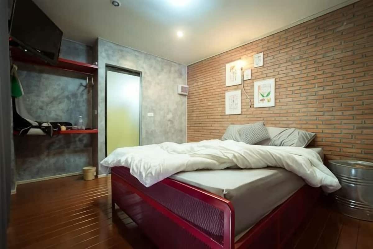 Une chambre Ă coucher avec un lit, un mur en briques et une porte.