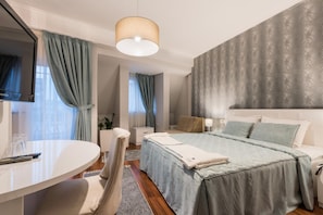 A modern hotel room with a bed, bedside table, and a TV. - Sultan Modern Hotel (Skopje)