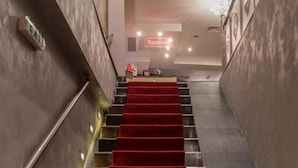 A staircase with red carpeted steps leading to a reception area. - Sultan Modern Hotel (Skopje)
