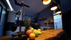 Une cuisine équipée d'un extracteur de jus, avec des fruits et un plan de travail en bois.