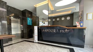 Un comptoir d’accueil moderne doté d’une cloison en verre, d’un annuaire numérique et d’une horloge indiquant plusieurs fuseaux horaires.
