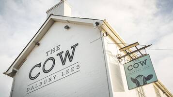 Een gebouw met een bord waarop 'The Cow Dalbury Lees' staat.