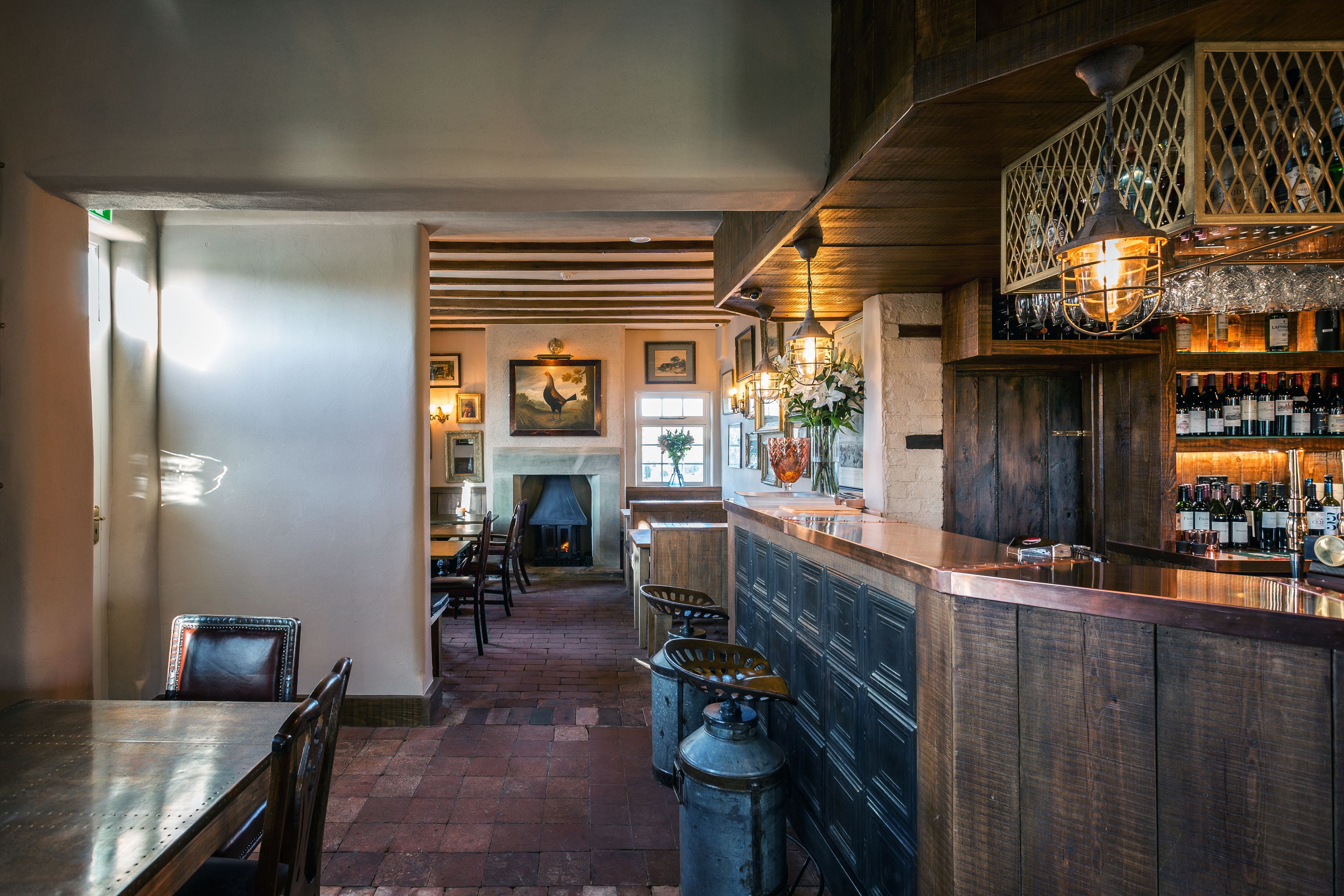 A bar area with wooden bar counters, a fireplace, and a dining area with chairs and a table.