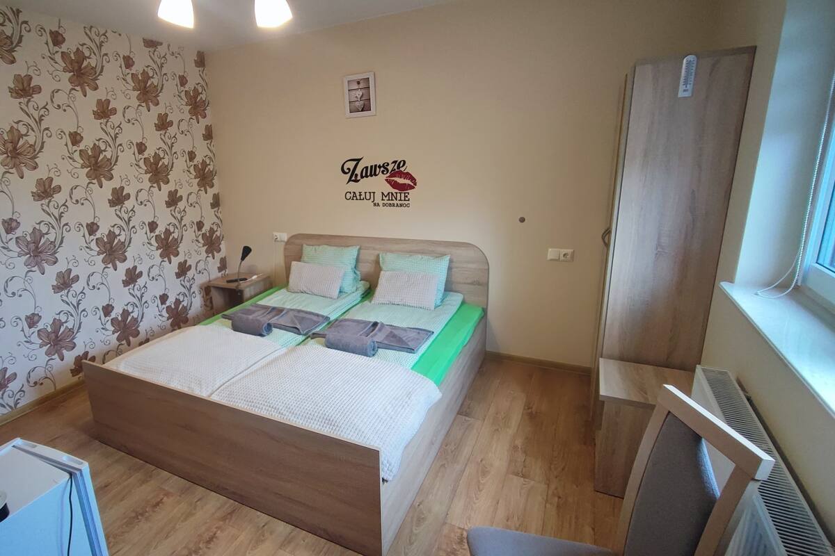 Une chambre à coucher avec un lit, une table de chevet, une armoire et une fenêtre.