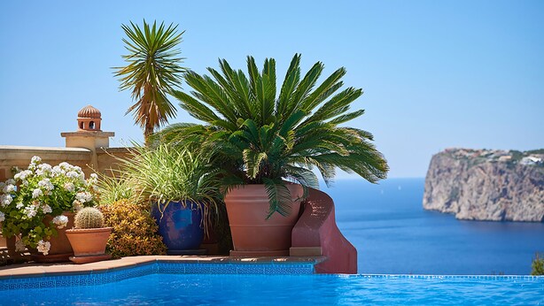 Una piscina con vista despejada al mar y a una costa rocosa.