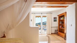 Un dormitorio con una cama, una estantería de madera y vistas al balcón exterior.