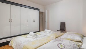 A hotel room with a bed, two pillows, a chair, and a wardrobe. - 1 bedroom nice apartment in Rabac (Rabac)